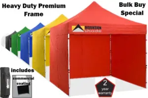 Row of colorful heavy-duty canopy tents with a red Mountain Shade tent in front label-bearing features like 2-year warranty and bulk buy offer.