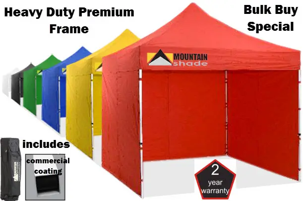 Row of colorful heavy-duty canopy tents with a red Mountain Shade tent in front label-bearing features like 2-year warranty and bulk buy offer.